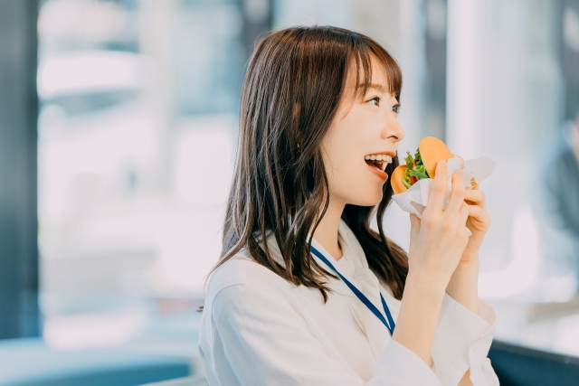 ハンバーガーを食べる女性